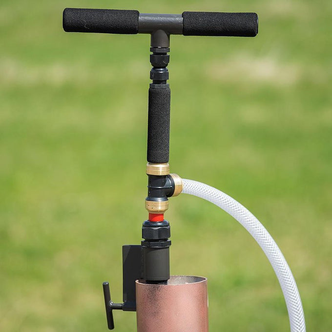 Hand pump with foam-grip handle connected to a copper well pipe and clear hose, designed for easy water access, part of Farm, Garden & Tool, Emergency Supplies, USA Made, and Water Pumps collections.
