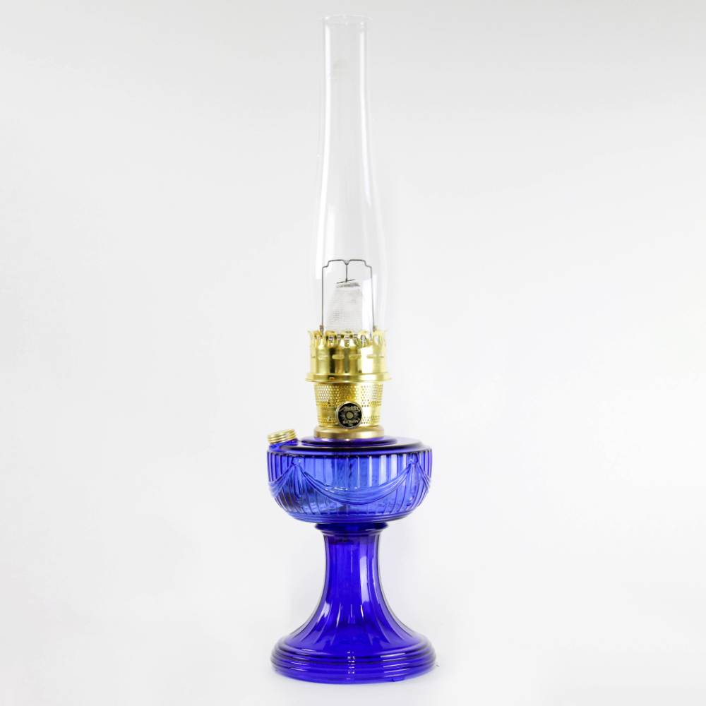 Handcrafted cobalt glass oil lamp with brass burner and tall clear chimney, featuring a vintage design, ideal for Lamps & Lighting, Oil Lamps, Table Lamps, Best Sellers, and Promo Eligible collections.