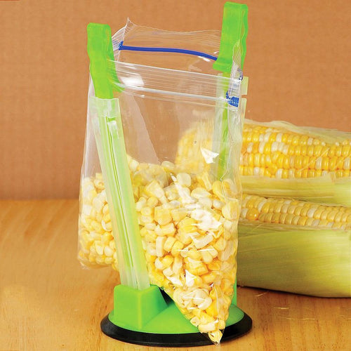 Green plastic bag holder with suction base keeping a zipper storage bag open for filling with corn kernels, designed for hands-free food preparation in Kitchen & Food, Kitchen Gadgets, and Cooking and Baking Helpers collections.