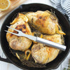High-quality stainless steel carving fork resting on golden roasted chicken thighs garnished with lemon slices and fresh herbs in a cast iron skillet, ideal for Kitchen & Food, Storage and Serving, USA Made, Best Sellers, and Promo Eligible collections.