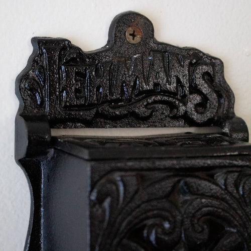 Handcrafted black cast iron wall-mounted matchbox holder with vintage decorative scrollwork and Lehman's branding, made in USA, featured in Home & Decor and Best Sellers collections.