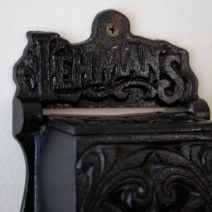 Handcrafted black cast iron wall-mounted matchbox holder with vintage decorative scrollwork and Lehman's branding, made in USA, featured in Home & Decor and Best Sellers collections.