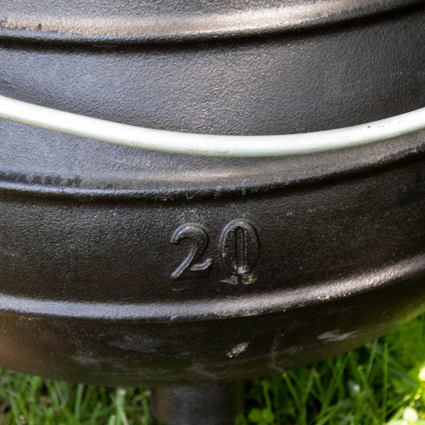 Close-up of a handcrafted cast iron campfire kettle showing the embossed number 20 on its durable, textured surface with a sturdy wire handle above, set on grass for Farm, Garden & Tool, Camping, Best Sellers, and Promo Eligible collections.