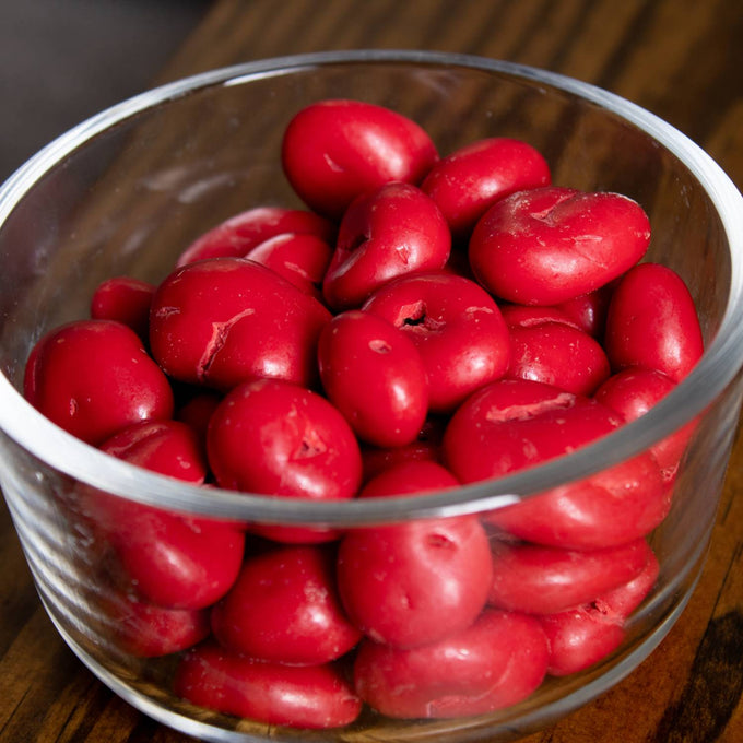 Glass bowl filled with glossy red chocolate covered cherries with a smooth candy coating, handcrafted and made in USA, ideal for Kitchen & Food, Snacks and Sweets, Candy, and Best Sellers collections.