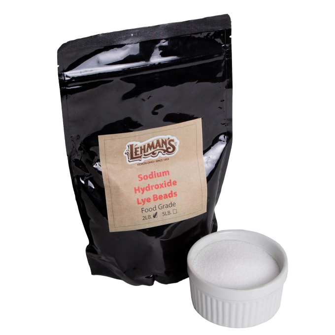 Resealable black pouch of handcrafted food-grade sodium hydroxide lye beads paired with a white ceramic ramekin of pure lye, ideal for soapmaking and health & wellness collections.