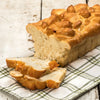 Sliced loaf of soft, freshly baked peach bread made with sweet peaches, displayed on a rustic cloth, ideal for Kitchen & Food, Snacks and Sweets, USA Made, and Best Sellers collections.