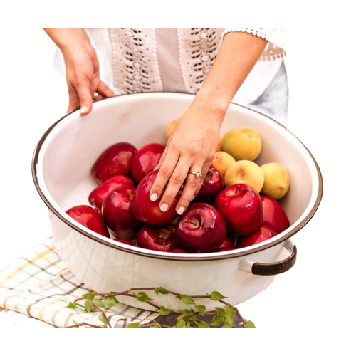 White enamelware basin with black-trimmed handles filled with red and yellow apples, styled for home, garden, camping, and household cleaning use.