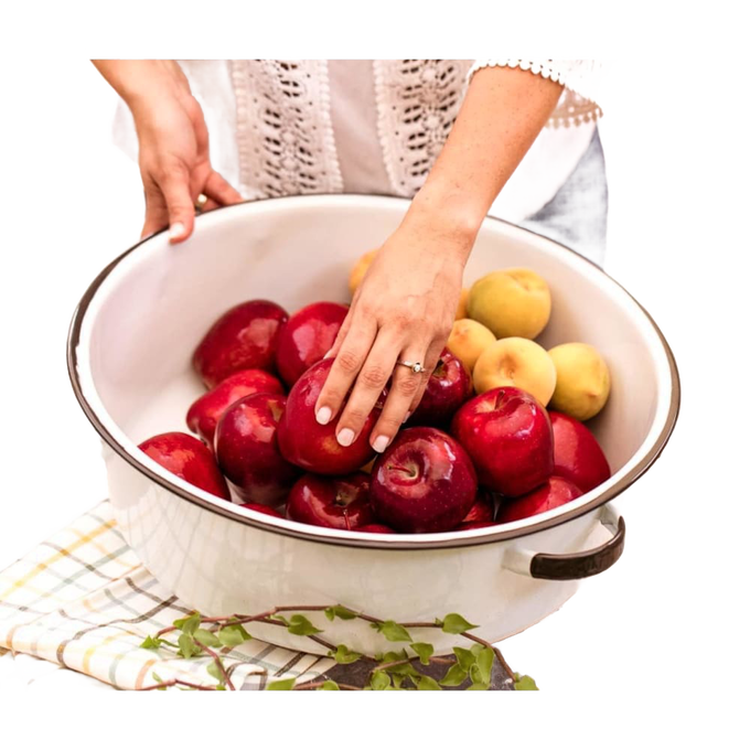 White enamelware basin with black-trimmed handles filled with red and yellow apples, styled for home, garden, camping, and household cleaning use.