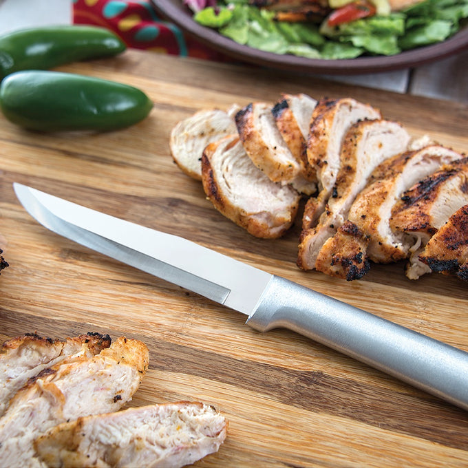 Handcrafted stainless steel knife with a silver brushed aluminum handle resting on a wooden cutting board with sliced grilled chicken, featured in Farm, Garden & Tool and Kitchen & Food collections.