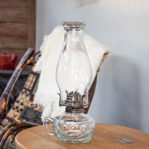 Handcrafted clear glass oil lamp with a unique finger hold on the side, featuring a tall chimney and ornate base, ideal for lamps & lighting, oil lamps, and table lamps collections.