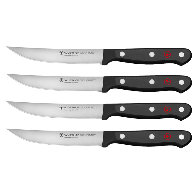 Set of four high-carbon stainless steel steak knives with triple-riveted black synthetic handles, designed for Kitchen & Food, Knives & Axes, and Best Sellers collections.
