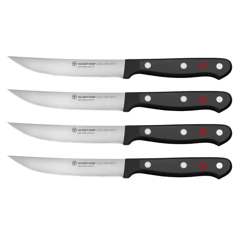 Set of four high-carbon stainless steel steak knives with triple-riveted black synthetic handles, designed for Kitchen & Food, Knives & Axes, and Best Sellers collections.
