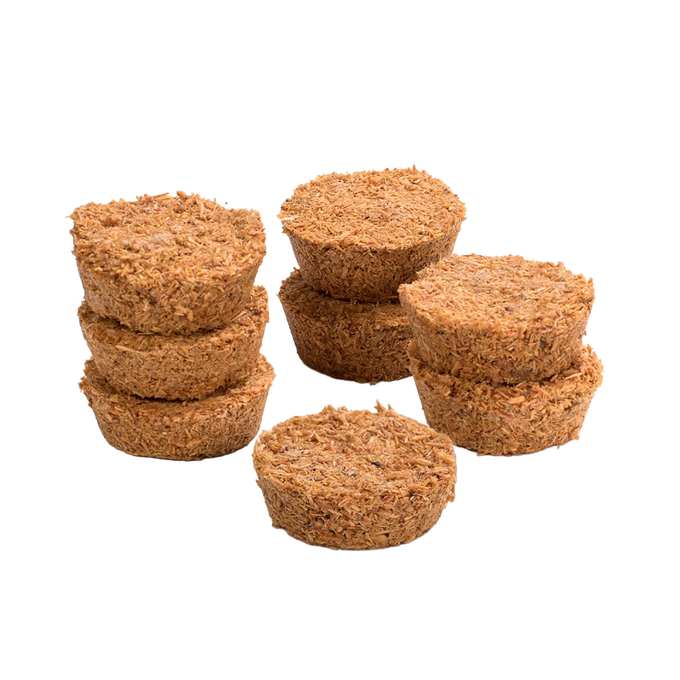 Eight handcrafted Fatwood Firedrops made from natural sawdust and paraffin, arranged in small stacked piles, perfect for camping, emergency supplies, and outdoor fire-starting.