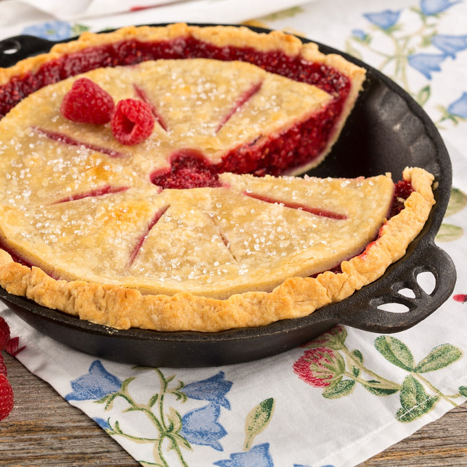 Handcrafted cast iron pie pan with decorative crimped edges baking a golden raspberry pie, featured in Kitchen & Food, Cast Iron, Cookware, Baking Supplies, Best Sellers, and Promo Eligible collections.