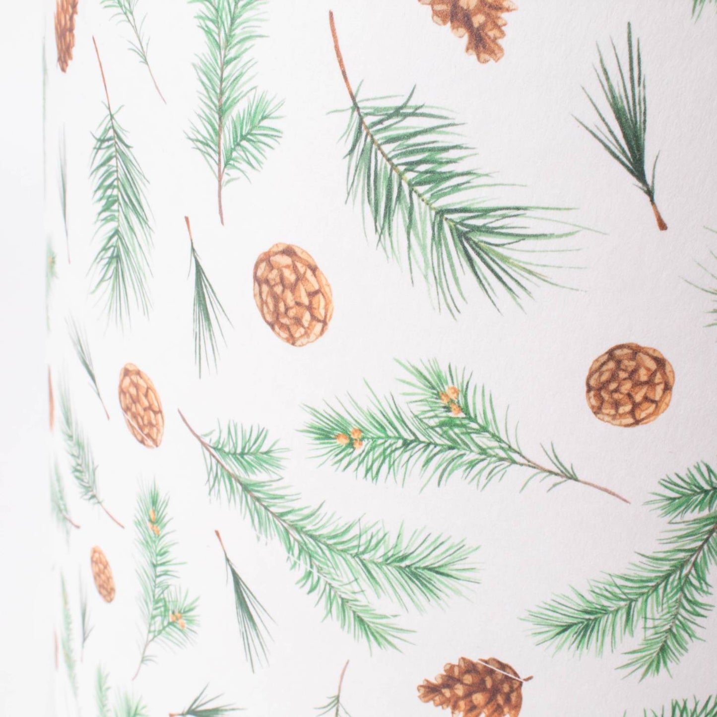 Close-up of a 12-inch parchment lamp shade featuring a delicate pine bough and pinecone pattern, handcrafted to create a warm glow, ideal for Lamps & Lighting and Lamp Shades collections.