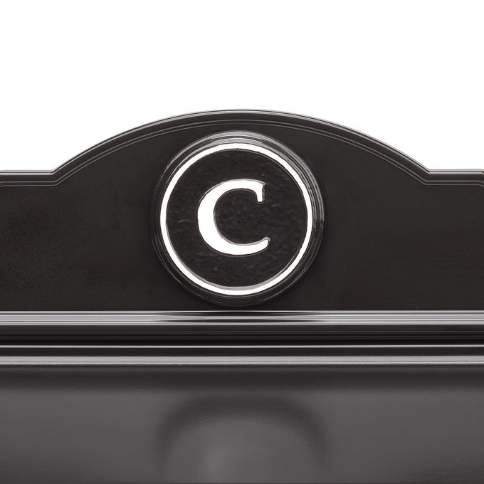 Close-up of a handcrafted black and white custom wall mount mailbox featuring a raised circular monogram letter "C," designed to enhance curb appeal in Home & Decor and USA Made collections.