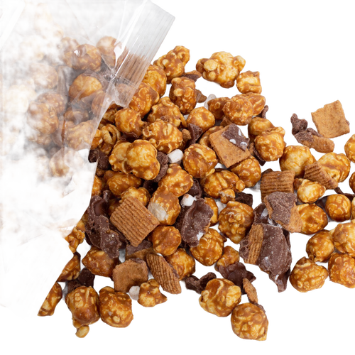 Clear bag spilling handcrafted caramel popcorn mixed with chocolate pieces and crunchy cereal bites, a unique sweet and crunchy snack made in USA, perfect for Kitchen & Food, Snacks and Sweets, Popcorn, USA Made, Best Sellers, and Promo Eligible collections.