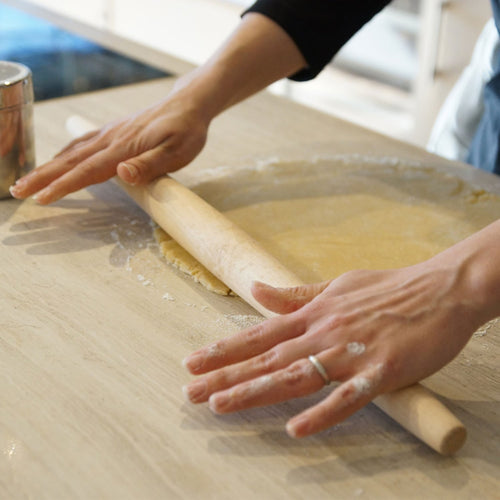 Hands using a handcrafted French-style hardwood rolling pin to evenly roll dough on a floured surface, featured in Kitchen & Food, Cookware, Baking Supplies, USA Made, Best Sellers, and Promo Eligible collections.