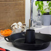Cast iron poultry roaster with central cone and dual handles set on a kitchen counter beside fresh mushrooms and sliced carrots, ideal for Kitchen & Food, Cookware, Cast Iron collections.