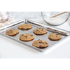 Stainless steel all-purpose jelly roll pan with a smooth, scratch-resistant surface holding freshly baked chocolate chip cookies, ideal for Kitchen & Food, Baking Supplies, and Cookware collections.
