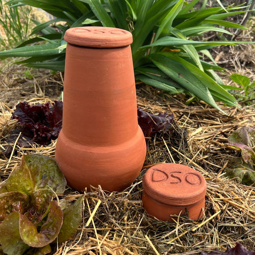 Unglazed terra cotta irrigation pot and lid with carved top, handcrafted for efficient water conservation in small garden beds and planters, featured in Farm, Garden & Tool collections.