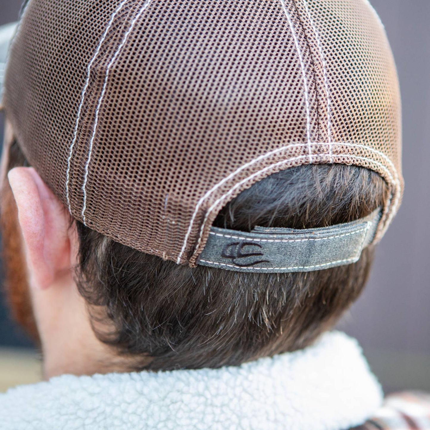 Adjustable mesh back hat with weathered cotton fabric and a vintage-style leather patch, featuring a hook and loop closure for a comfortable fit in Health & Wellness and Clothing collections.