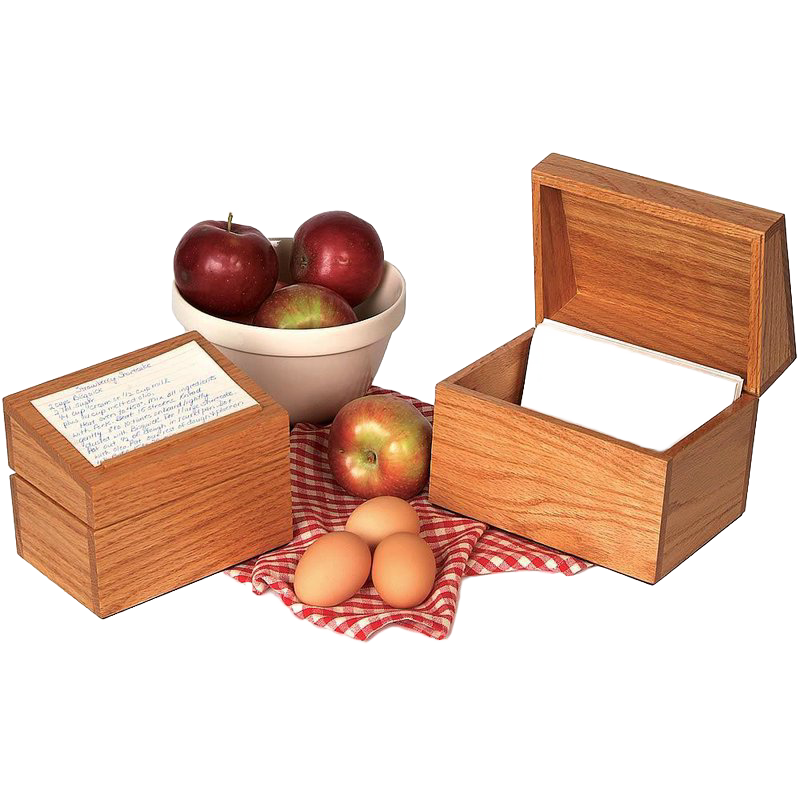 Handcrafted solid oak recipe box with smooth protective finish and recessed hinges, accompanied by apples in a bowl, fresh apples, and eggs on a red checkered cloth, ideal for Kitchen & Food, Cookware, Baking Supplies, Holiday Hosting, Kitchen Gadgets, Kitchen Accessories, Storage and Serving, USA Made, Best Sellers, and Promo Eligible collections.