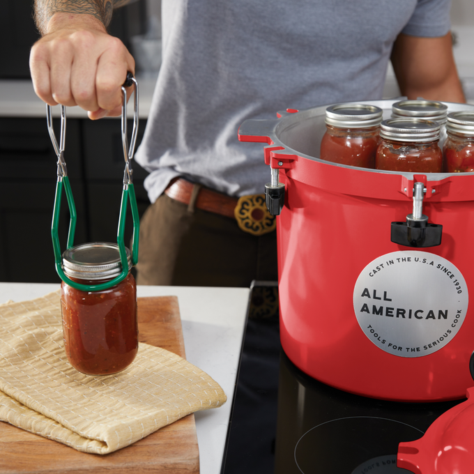 Handcrafted All American 21-1/2 Qt pressure canner in vibrant color with secure locking clamps, shown with jars of preserved food, made in USA for Kitchen & Food, Food Preservation, Canning, Pressure Canners, and Best Sellers collections.