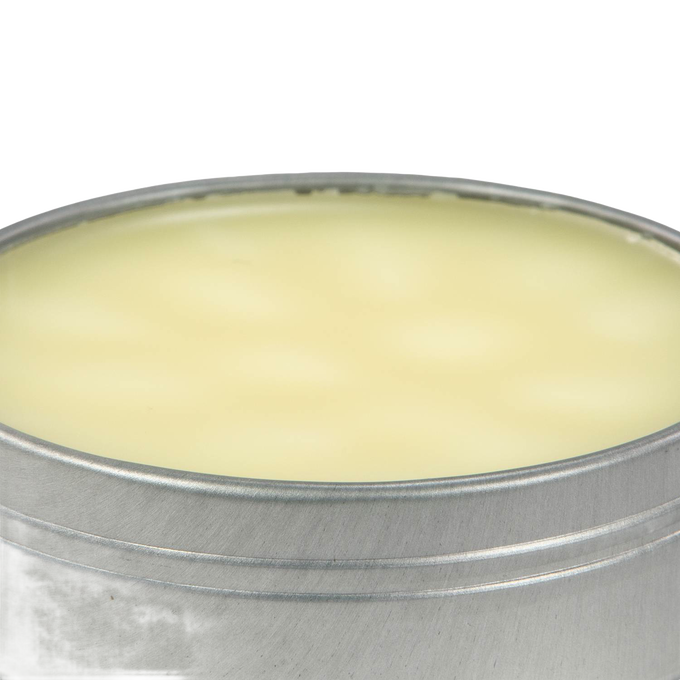 Open round metal tin filled with smooth pale yellow beeswax blend for seasoning and conditioning cast iron and carbon steel cookware, USA made kitchen essential