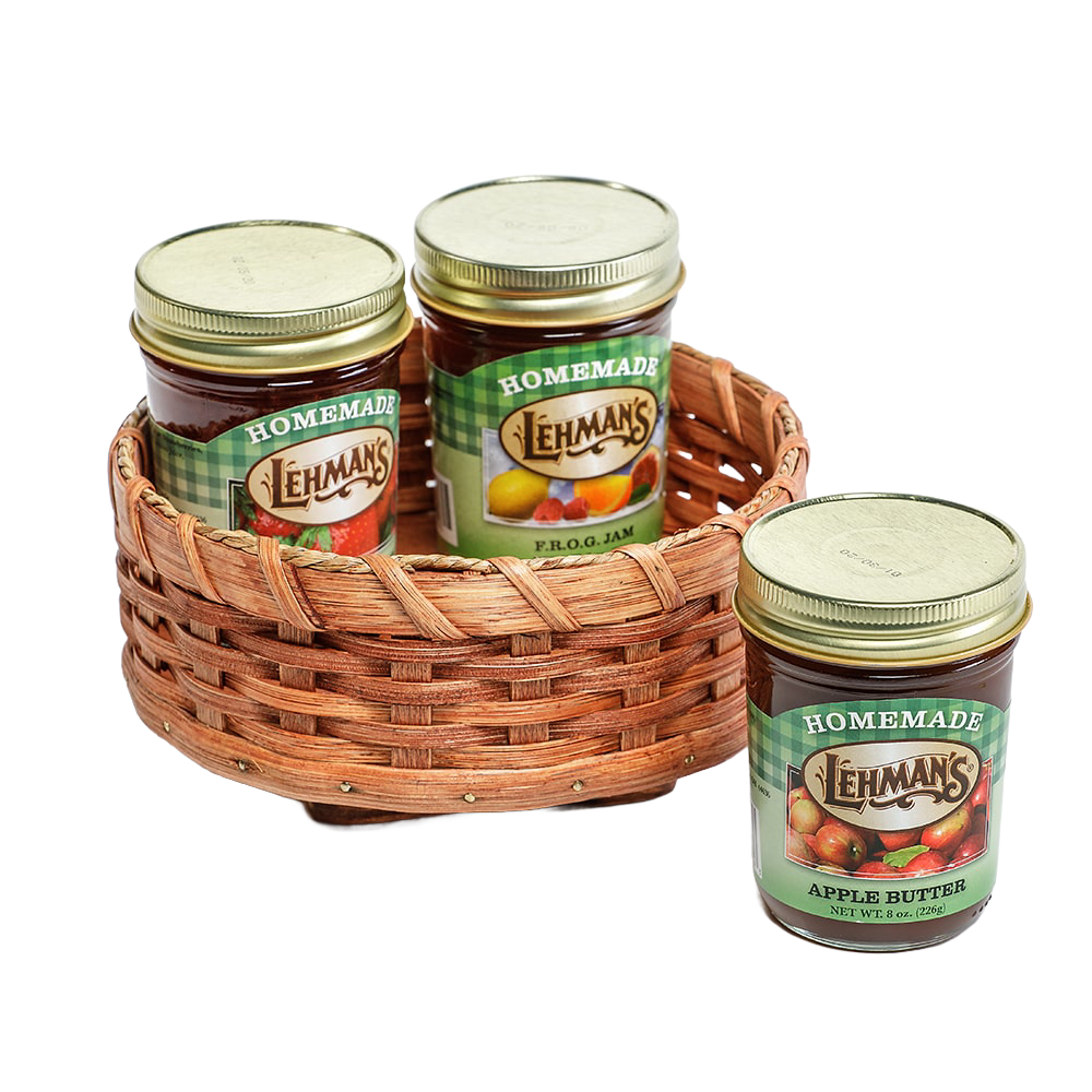 Handcrafted Amish-made rotating lazy Susan basket woven from basket reed with a poplar base, holding glass jars of homemade jams and preserves, ideal for kitchen accessories.