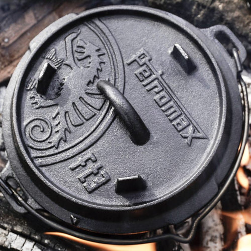 Close-up of a sturdy cast iron Dutch oven lid with embossed logo and decorative pattern, designed for versatile outdoor and indoor cooking in Kitchen & Food, Cast Iron, Best Sellers, and Promo Eligible collections.