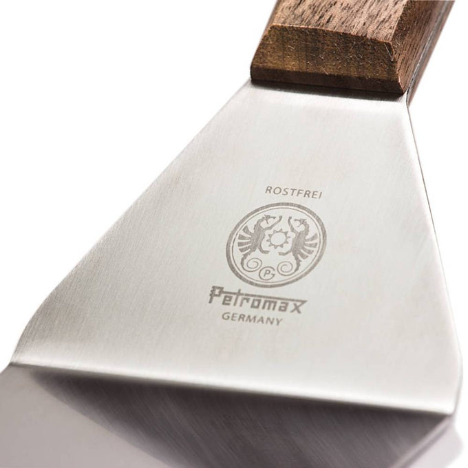 Close-up of a stainless steel spatula blade with engraved logo and a smooth wooden handle, designed for versatile use in kitchen gadgets, grilling, and cooking helpers collections.