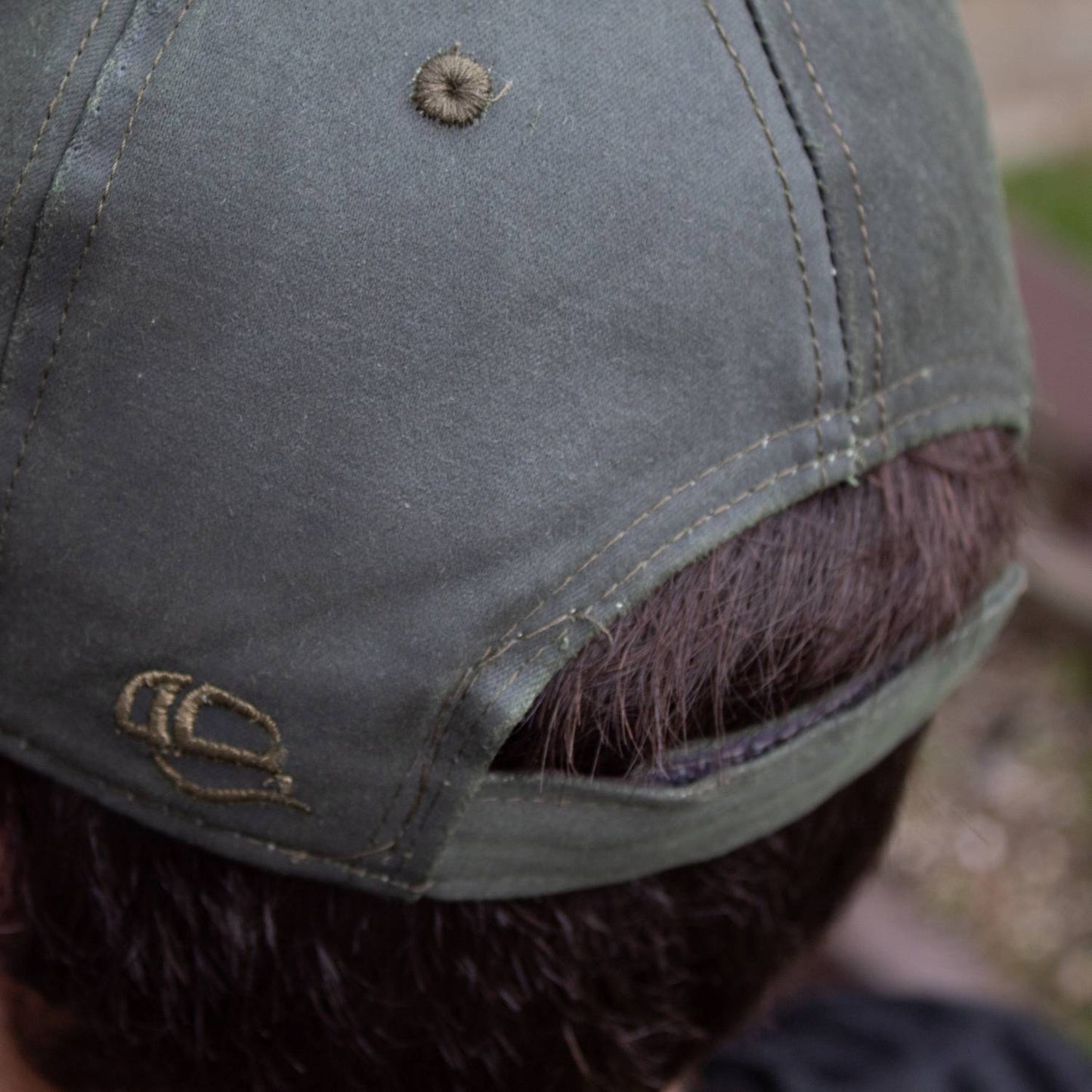 Close-up of the back of a handcrafted adjustable hat in washed cotton with hook and loop closure, featuring a stitched logo, ideal for Health & Wellness, Clothing and Accessories, Best Sellers, and Promo Eligible collections.