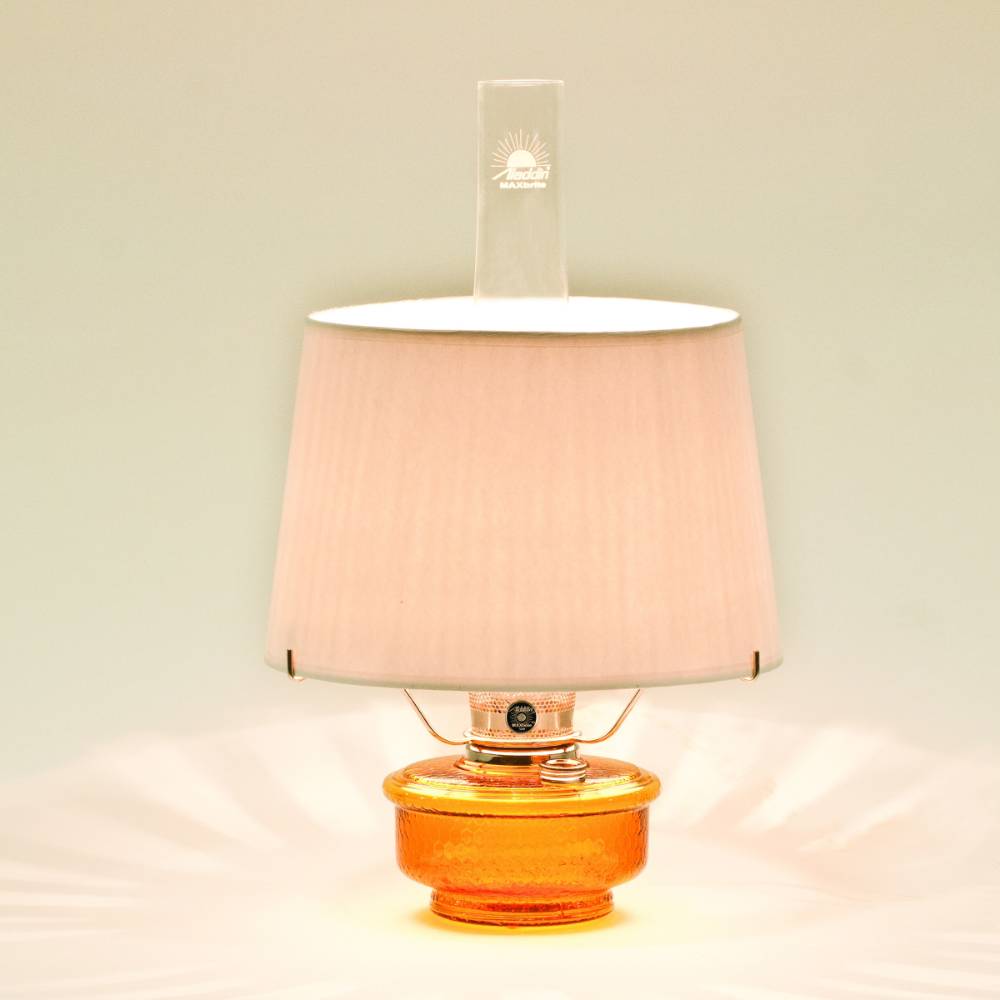Amber glass oil lamp with a white parchment shade emitting warm light, designed for emergency use and decorative table lighting in Farm, Garden & Tool and Lamps & Lighting collections.