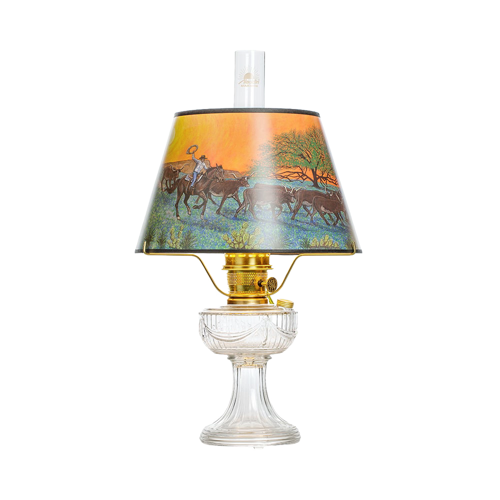 Unique handcrafted oil lamp with clear USA-made glass base and brass burner, featuring a colorful scenic shade depicting riders and cattle, part of Lamps & Lighting, Oil Lamps, Table Lamps, Best Sellers, and Promo Eligible collections.
