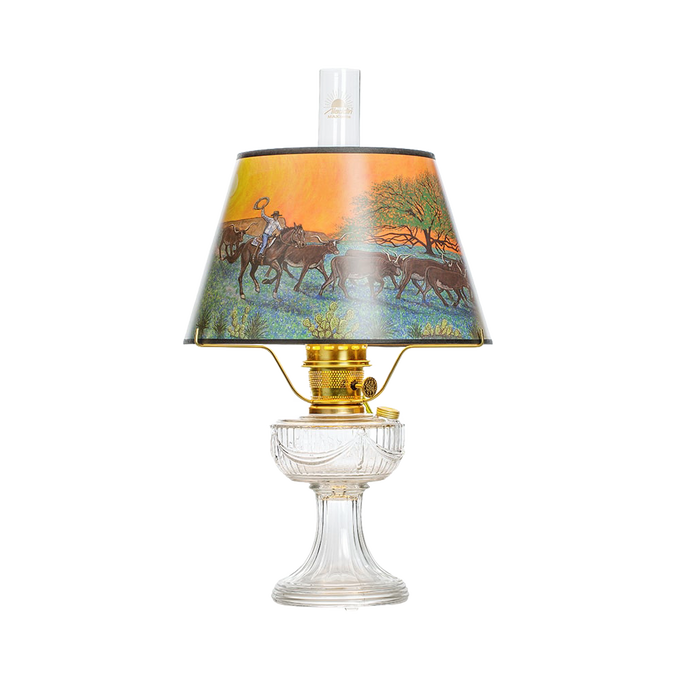 Unique handcrafted oil lamp with clear USA-made glass base and brass burner, featuring a colorful scenic shade depicting riders and cattle, part of Lamps & Lighting, Oil Lamps, Table Lamps, Best Sellers, and Promo Eligible collections.