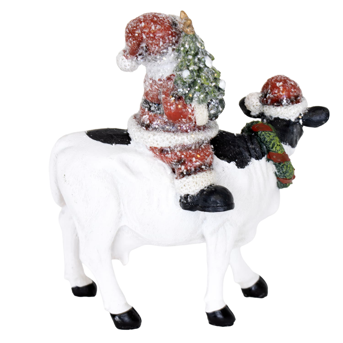 Handcrafted 6-inch resin figurine featuring Santa holding a Christmas tree while riding a black and white cow wearing a festive wreath and Santa hat, adding cozy country charm to Home & Decor, Holiday Decor, Best Sellers, and Promo Eligible collections.