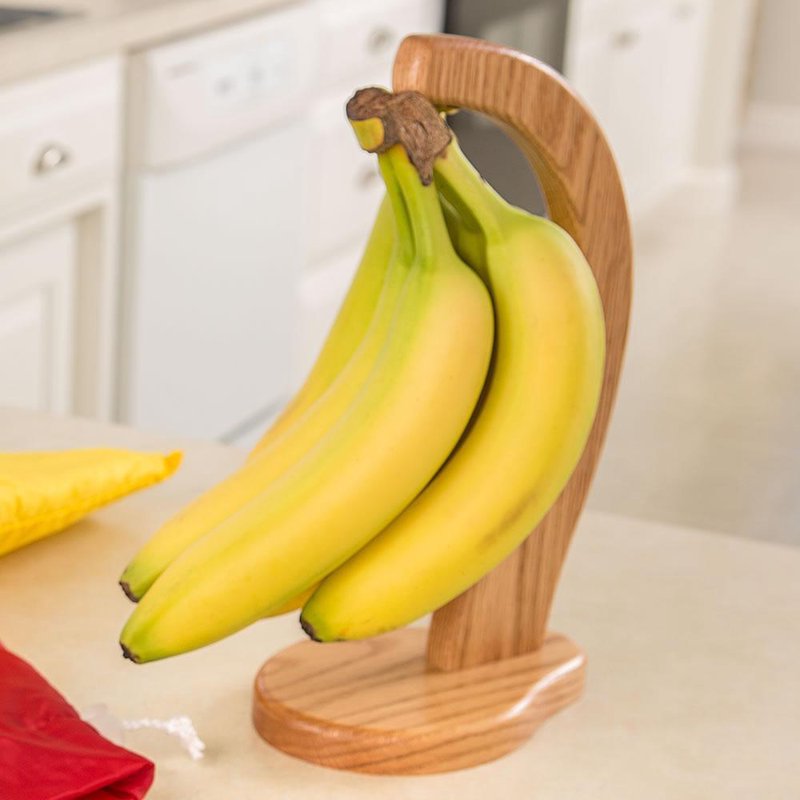 Handcrafted Amish-made banana holder with smooth honey brown wood finish, designed for kitchen and food storage, promoting air circulation and bruise-free ripe bananas.