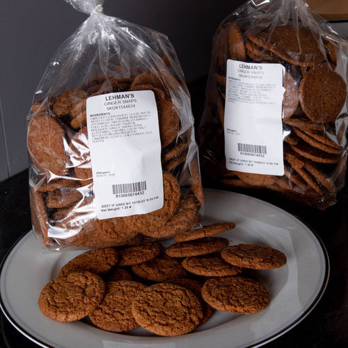 Two clear bags filled with handcrafted crispy ginger snap cookies made in USA, with several cookies arranged on a white plate, highlighting warm spices and classic texture, featured in Kitchen & Food, Snacks and Sweets, and USA Made collections.
