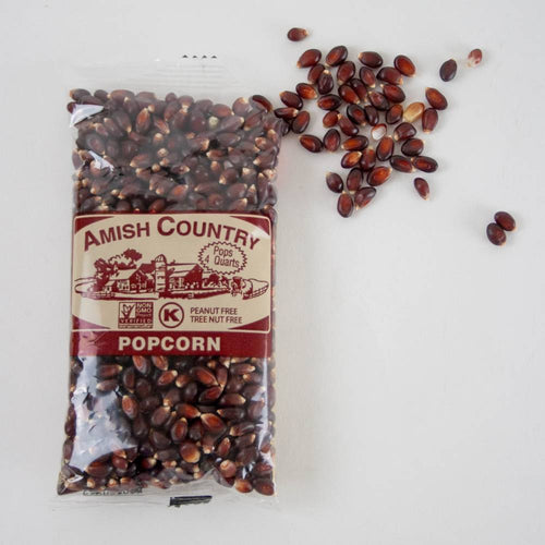 Handcrafted Amish Country popcorn kernels in a clear bag with scattered deep reddish-brown kernels, perfect for kitchen and food, snacks, and USA made collections.