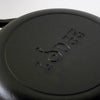 Close-up of the bottom of a handcrafted black cast iron skillet embossed with "Lodge," ideal for Kitchen & Food, Cookware, Cast Iron, USA Made, Best Sellers, and Promo Eligible collections.