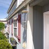Handcrafted silver windchime with wooden accents hanging from a porch beam against a gray house with red trim, featured in Farm, Garden & Tool and Garden Accessories collections.