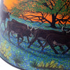 Southwestern-inspired parchment oil lamp shade featuring handcrafted artwork of longhorn cattle walking through bluebonnet fields beneath a vibrant orange sunset and silhouetted tree, part of Lamps & Lighting and Lamp Shades collections.