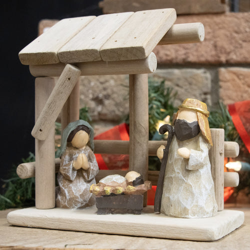 Handcrafted nativity scene featuring a small wooden stable with attached resin figurines of the Holy Family, perfect for Home & Decor, Holiday Decor, Best Sellers, and Promo Eligible collections.