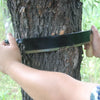 Person using a sharpened 10-inch curved draw shave with comfortable wood handles to shave bark from a tree, ideal for Farm, Garden & Tool and Wood Cutting collections.