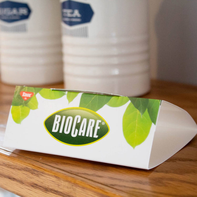 White and green rectangular cardboard box branded BioCare with leaf design, placed on wooden surface, suitable for Home & Decor, Farm, Garden & Tool, Pest Control, Household Helpers, USA Made collections.