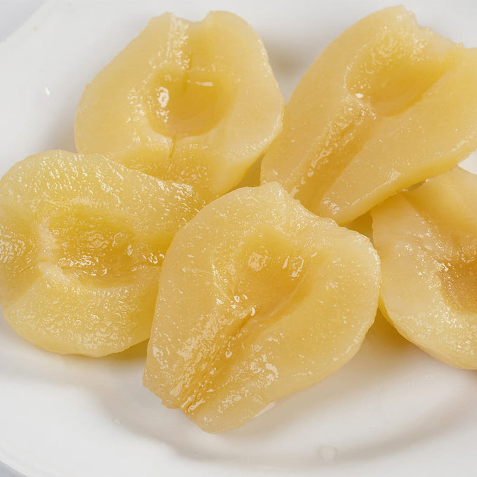 Close-up of juicy canned Bartlett pear halves with a natural sweetness, showcased on a white plate, perfect for Kitchen & Food, Snacks and Sweets, Pantry, USA Made, Best Sellers, and Promo Eligible collections.