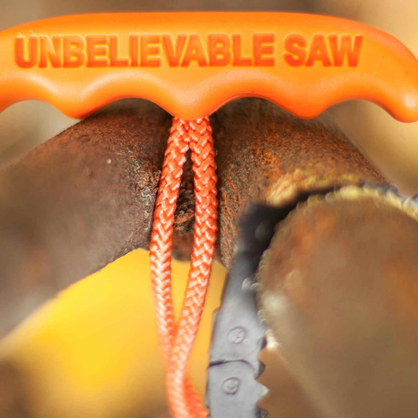 Close-up of an orange handle with the text "UNBELIEVABLE SAW" on a compact pocket chain saw cutting through a rusty metal pipe, highlighting a durable tool from USA made Farm, Garden & Tool and Camping collections.