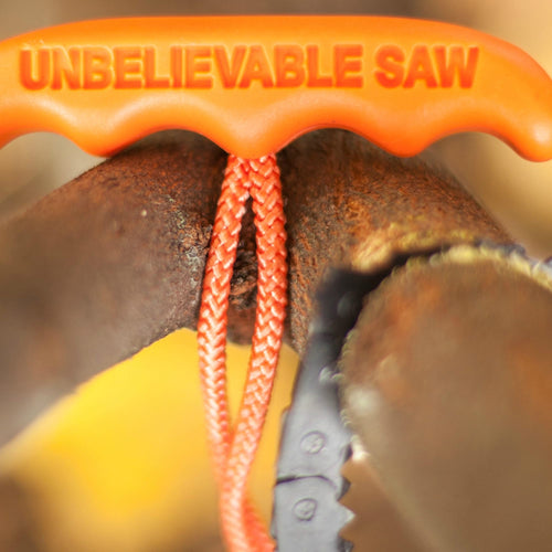Close-up of an orange handle with the text "UNBELIEVABLE SAW" on a compact pocket chain saw cutting through a rusty metal pipe, highlighting a durable tool from USA made Farm, Garden & Tool and Camping collections.