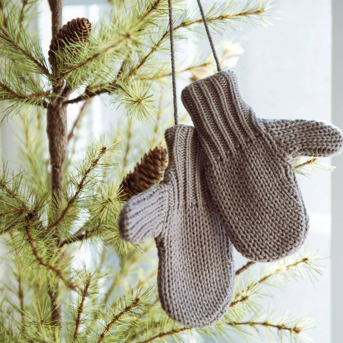 Pair of gray cotton blend mittens hanging on a pine tree branch, adding a cozy touch to holiday decor, featured in Home & Decor and Holiday Decor collections.